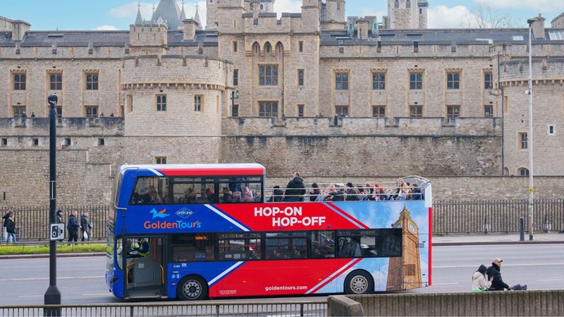 Tick off London’s most iconic attractions on a hop-on hop-off bus tour. Image courtesy of Golden Tours. Hop-on hop-off bus driving past Tower of London.