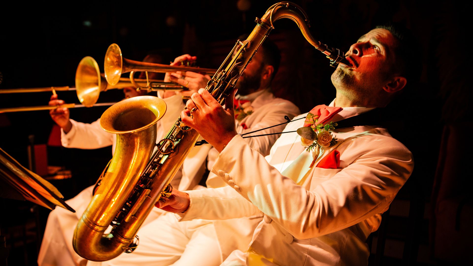 Watch brilliant live bands at the immersive 1930s New York jazz spectacular, 58th Street. Image courtesy of The Lost Estate. A trio of brass band players with a saxophone and trumpet in white suit jackets.