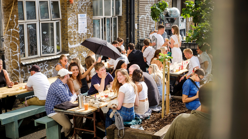 Make memories over pints with friends during the summer months at Crate Brewery. Credit: Robin Pearson. Image courtesy of Crate Brewery. Groups of friends smile and chat together in the sun whilst sat on the outdoor tables at Crate Brewery