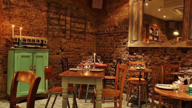 Treat yourself to modern takes on classic Parisian dishes. Image courtesy of Blanchette. The cosy, rustic dining room at French restaurant Blanchette, with wooden tables, wooden chairs, brick walls and candles.