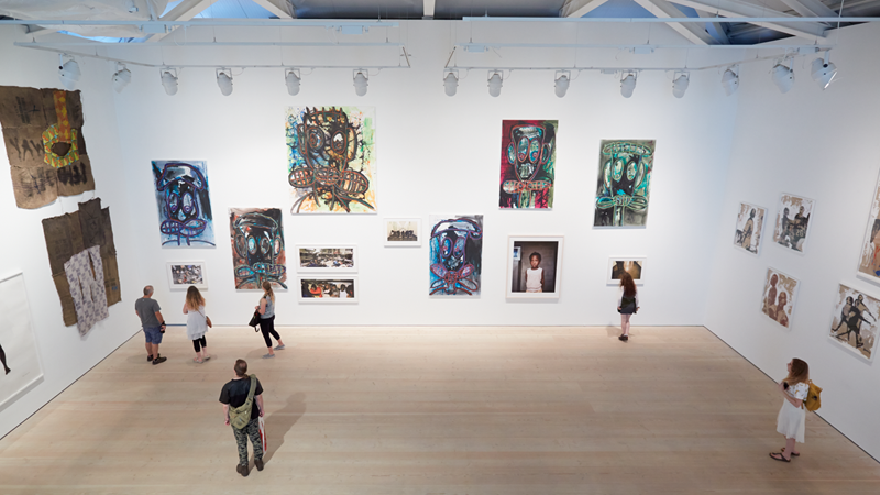 Catch world-class exhibitions and artwork at Saatchi Gallery in Chelsea. Credit: Shutterstock. Image courtesy of Shutterstock. A view from inside the Saatchi Gallery looking down at people in a hall with huge white walls and wooden flooring, as they admire the artwork covering the walls