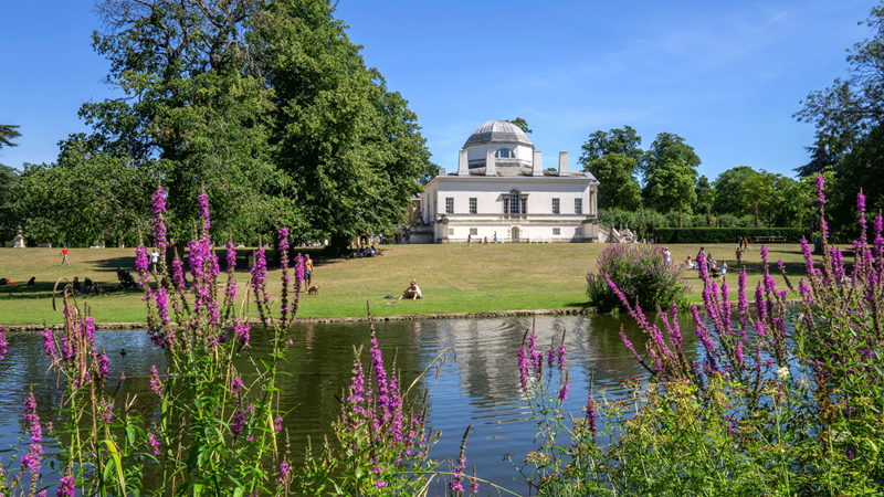 Explore the 18th century Chiswick House with its 65 acres of gardens. Credit: Shutterstock. Image courtesy of Shutterstock. View of Chiswick House with lake and flowers in front