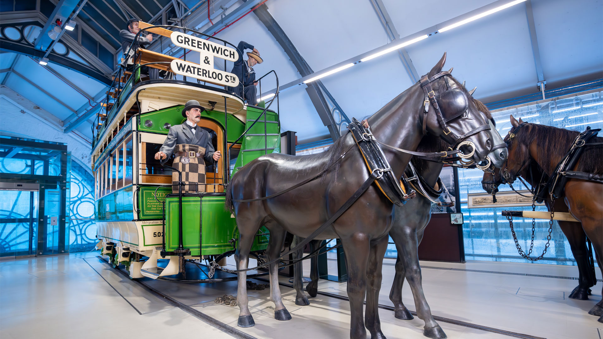 Explore interactive exhibits and London transport collections dating back to 1800 at London Transport Museum. Image courtesy of London Transport Museum. low angle photo of old London transport method of model horse and carriage with two doll mannequins sitting on the carriage