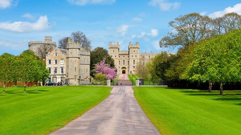 Windsor Castle and the luscious green gardens surrounding the grounds. Image courtesy of Shutterstock. External shot of Windsor Castle and the surrounding green grounds.