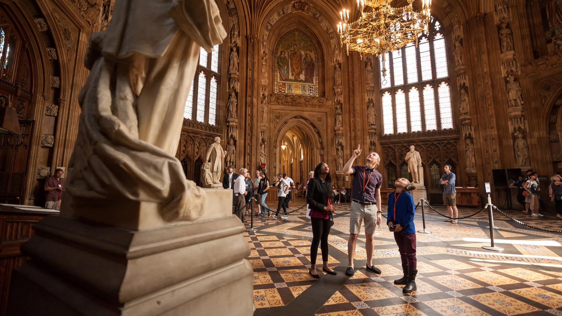 Participez à une visite auto guidée du Parlement anglais et apprenez-en plus sur les différents gouvernements. Image fournie par UK Parliament. Une famille visite les maisons du Parlement à Londres à l'aide d'un guide audio.