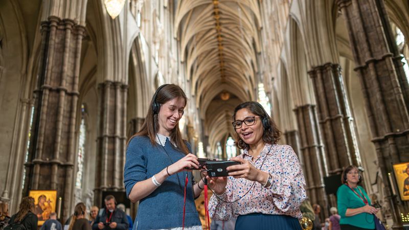 Use the audio guide as you visit Westminster Abbey and learn about historic events that took place at this beloved London attraction. ©London & Partners/Michael Barrow Two women are using the multi media guides during their visit of Westminster Abbey.