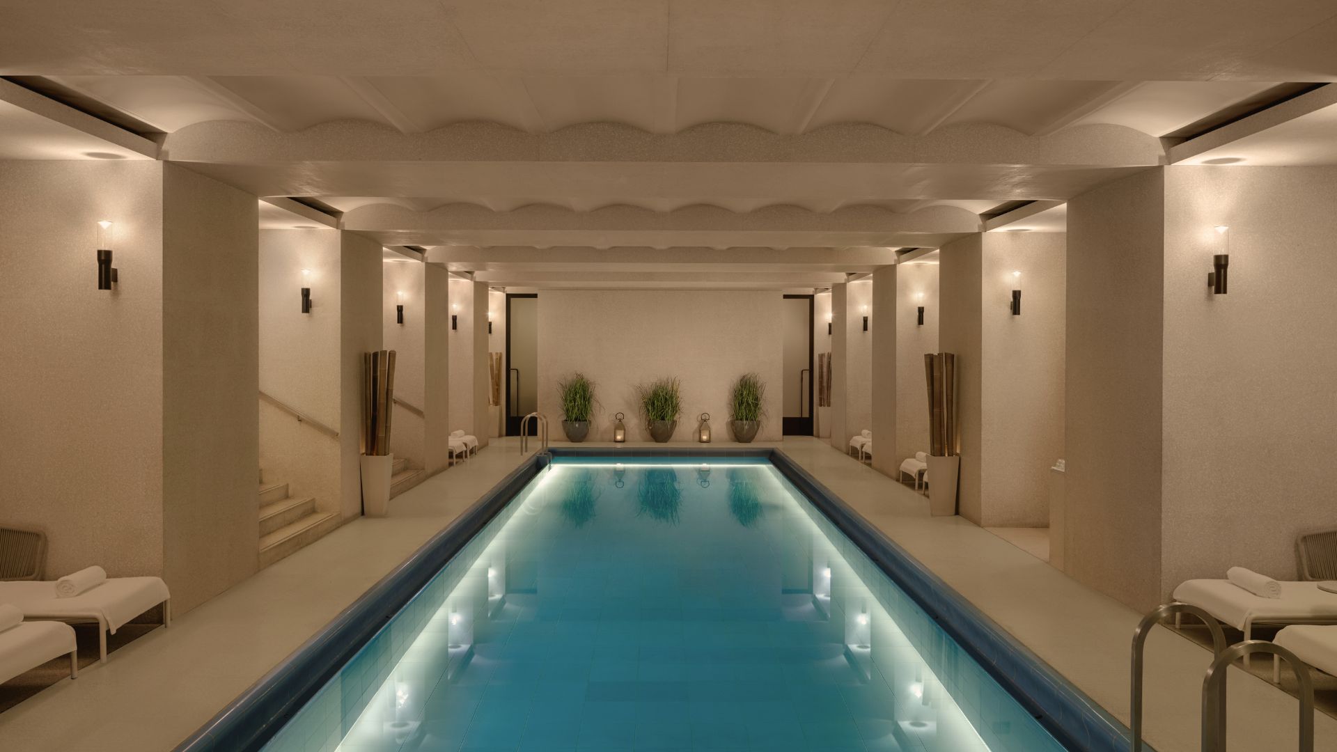 Akasha Spa at Hotel Café Royal. Image courtesy of Red Letter Days. tranquil spa room with cream walls, ceilings and flooring, mood lighting and a long pool with lights in the centre of the room