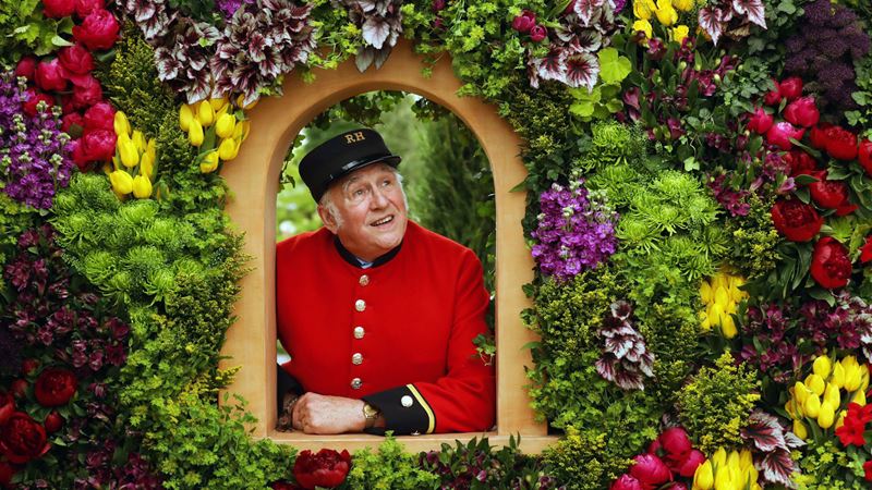 A Chelsea Pensioner poses on the Marks and Spencer Spirit of Summer: A Mediterranean Journey exhibit at the RHS Chelsea Flower 2017. Copyright: RHS/Luke MacGregor. Image courtesy of RHS. A Chelsea Pensioner poses on the Marks and Spencer Spirit of Summer: A Mediterranean Journey exhibit at the RHS Chelsea Flower 2017.