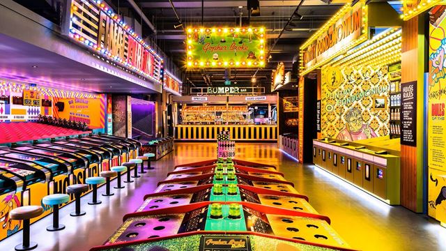 Brightly coloured old-school arcade games with yellow, purple and green lights.