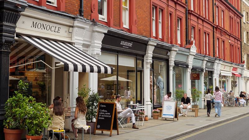 Black and white shopfronts on red brick buildings in Marylebone, with black and white striped awnings.