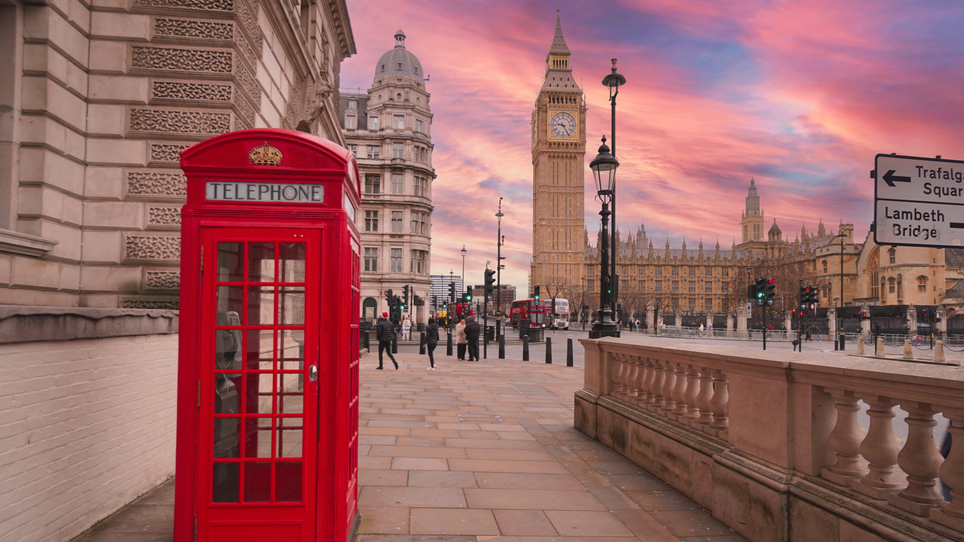 Pink sunset behind Big Ben with red telephone box in the foreground