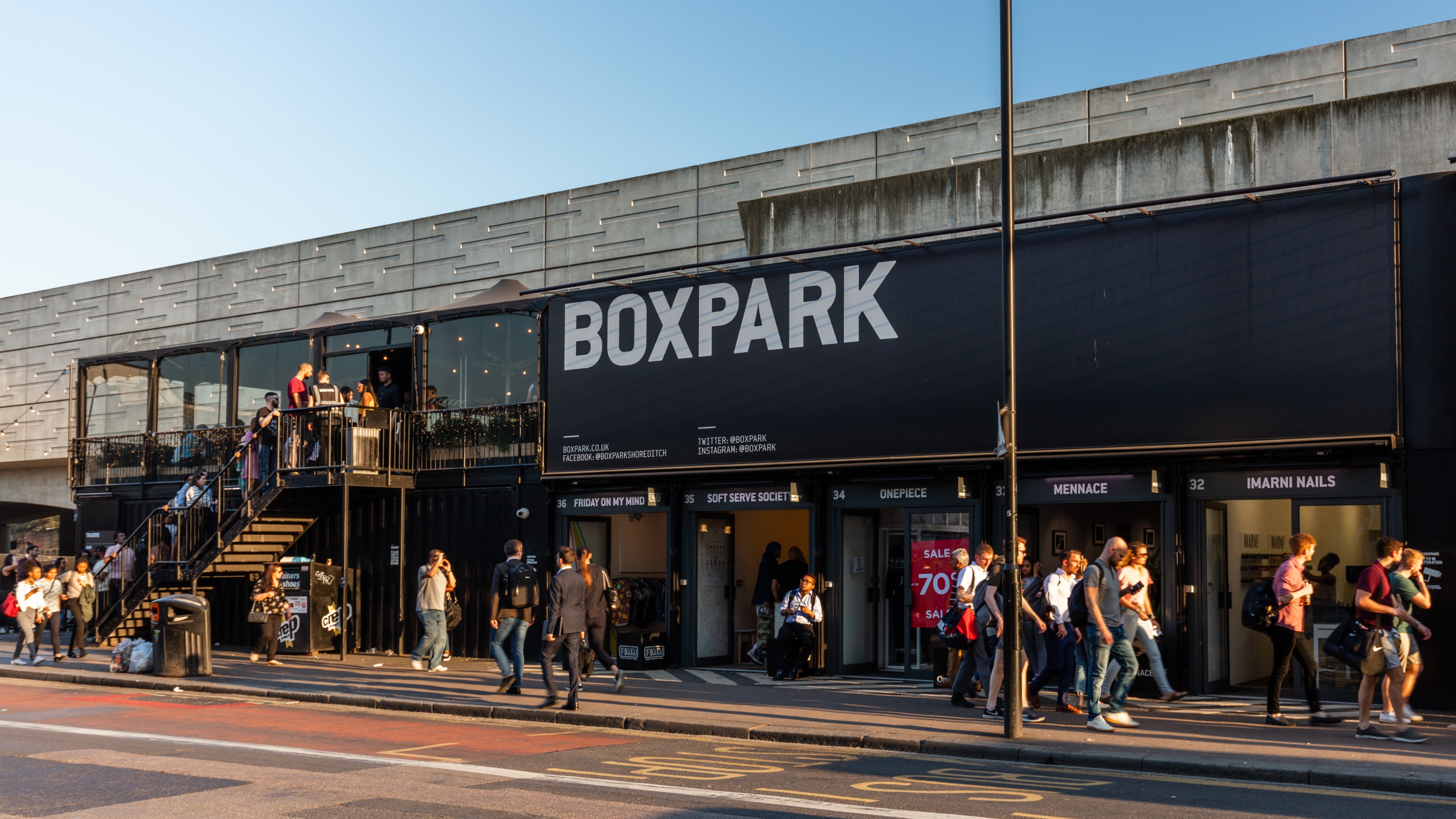 The exterior of container village Boxpark in Shoreditch, with shoppers and people queuing for the restaurants