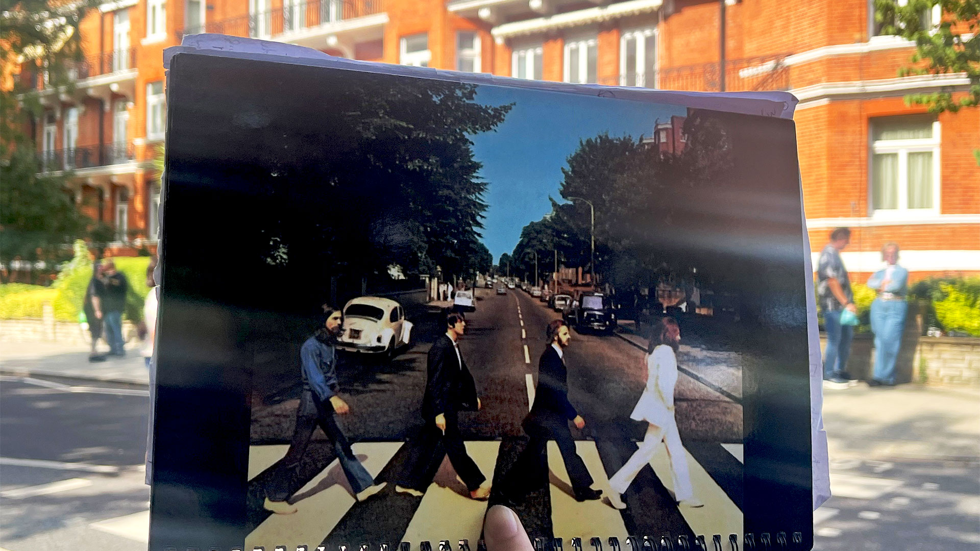 Follow in the footsteps of the Beatles at Abbey Road and recreate the famous album cover. Image courtesy of Carole Rocton. A photograph of the Abbey Road album cover is held up in front of the famous crossing.
