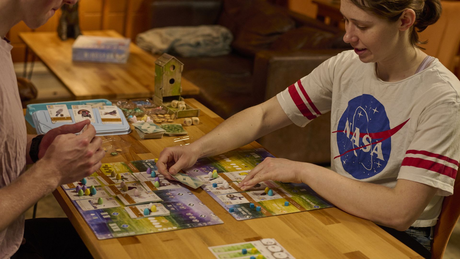 Two people playing a board game across a table at Otter Chaos.