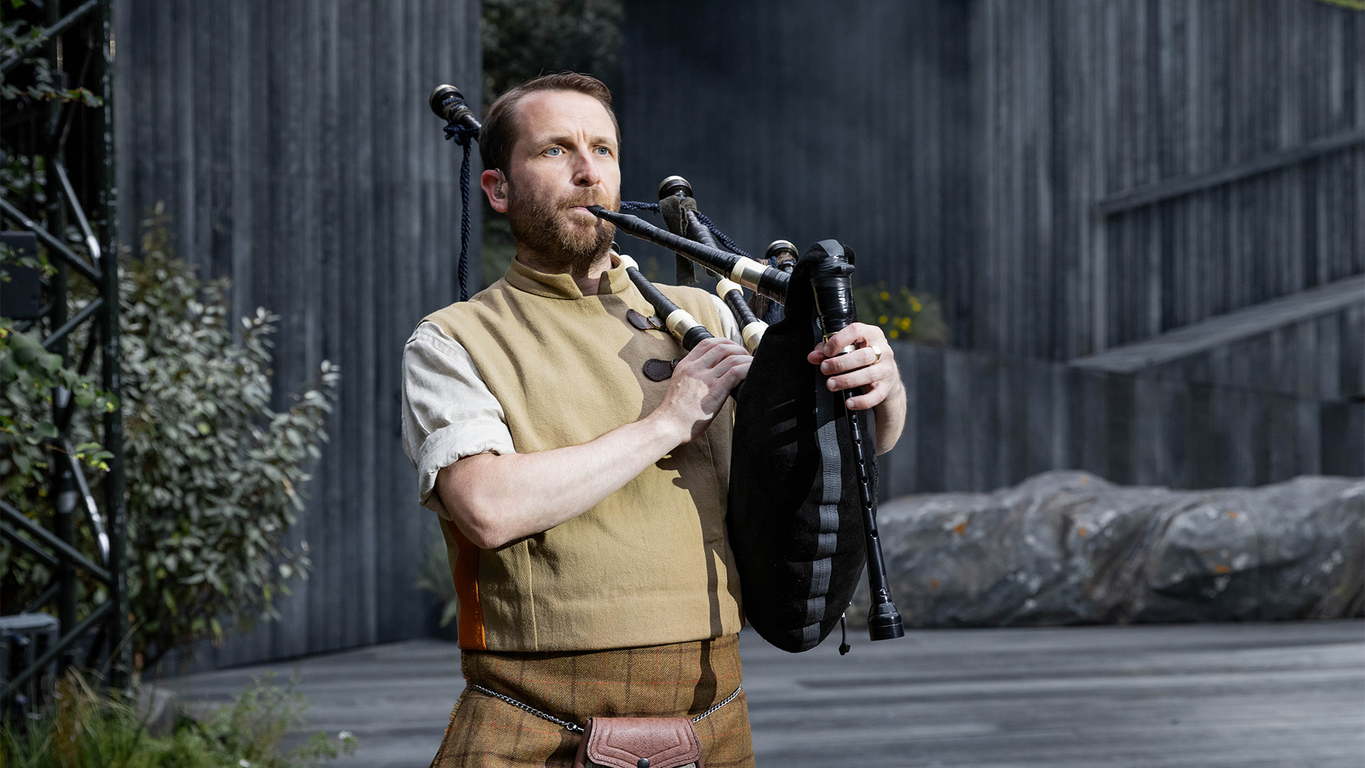A man plays the bagpipes in the opening of Brigadoon