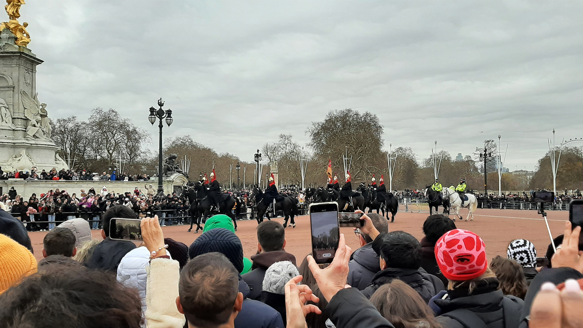 Witness the Changing the Guard from Victoria Monument at Buckingham Palace. Image courtesy of Visit London/Sigrun Tomicki A crowd of people are watching the Change of Guard mounted on horses at Victoria Monument