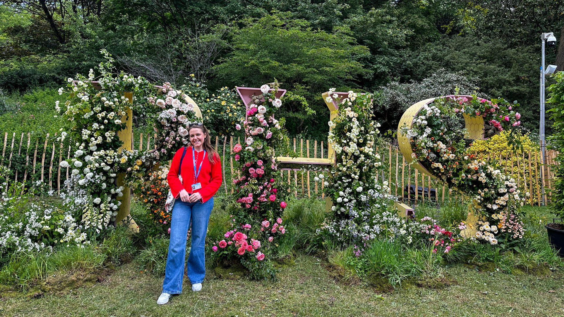 Stop by the floral RHS letters for one of the easiest photo opportunities at Chelsea Flower Show. Photo credit: Kirstine Spicer. Visitor posing beside large RHS floral letters installation.