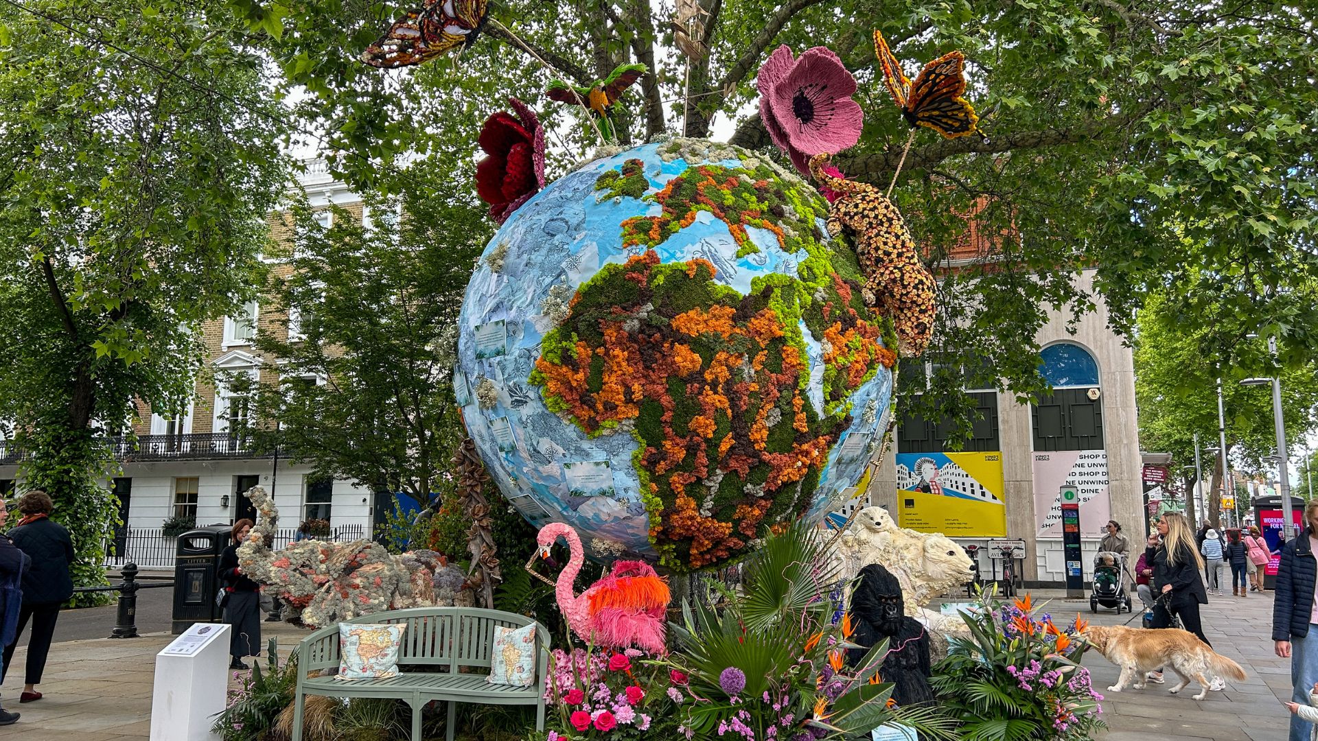 See inspiring floral installations at Chelsea in Bloom, including the Floral Globe on Royal Avenue. Image courtesy of Hannah Cornish. Large globe sculpture covered in plants and flowers, surrounded by floral animals including a flamingo and butterflies in a leafy London street