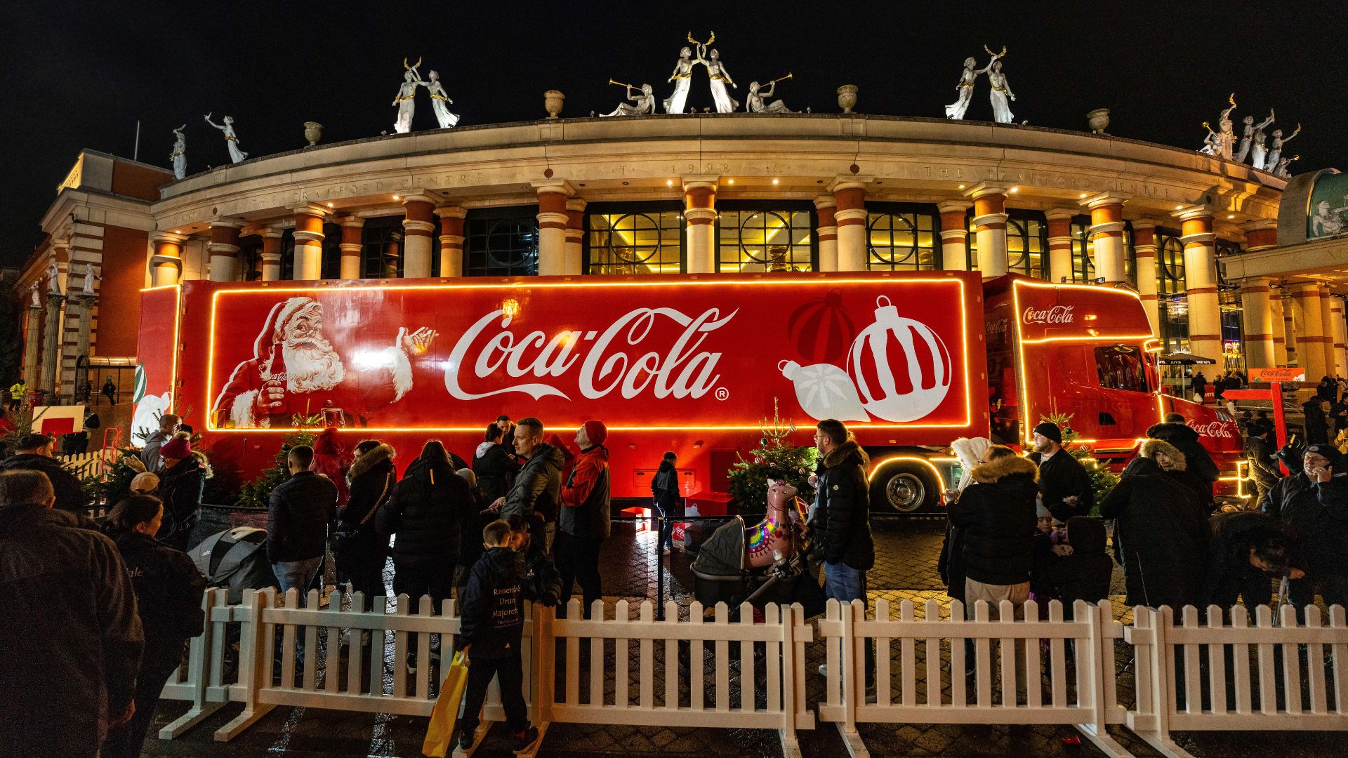 The Coca-Cola Christmas Truck on its tour in London, behind a white fence.