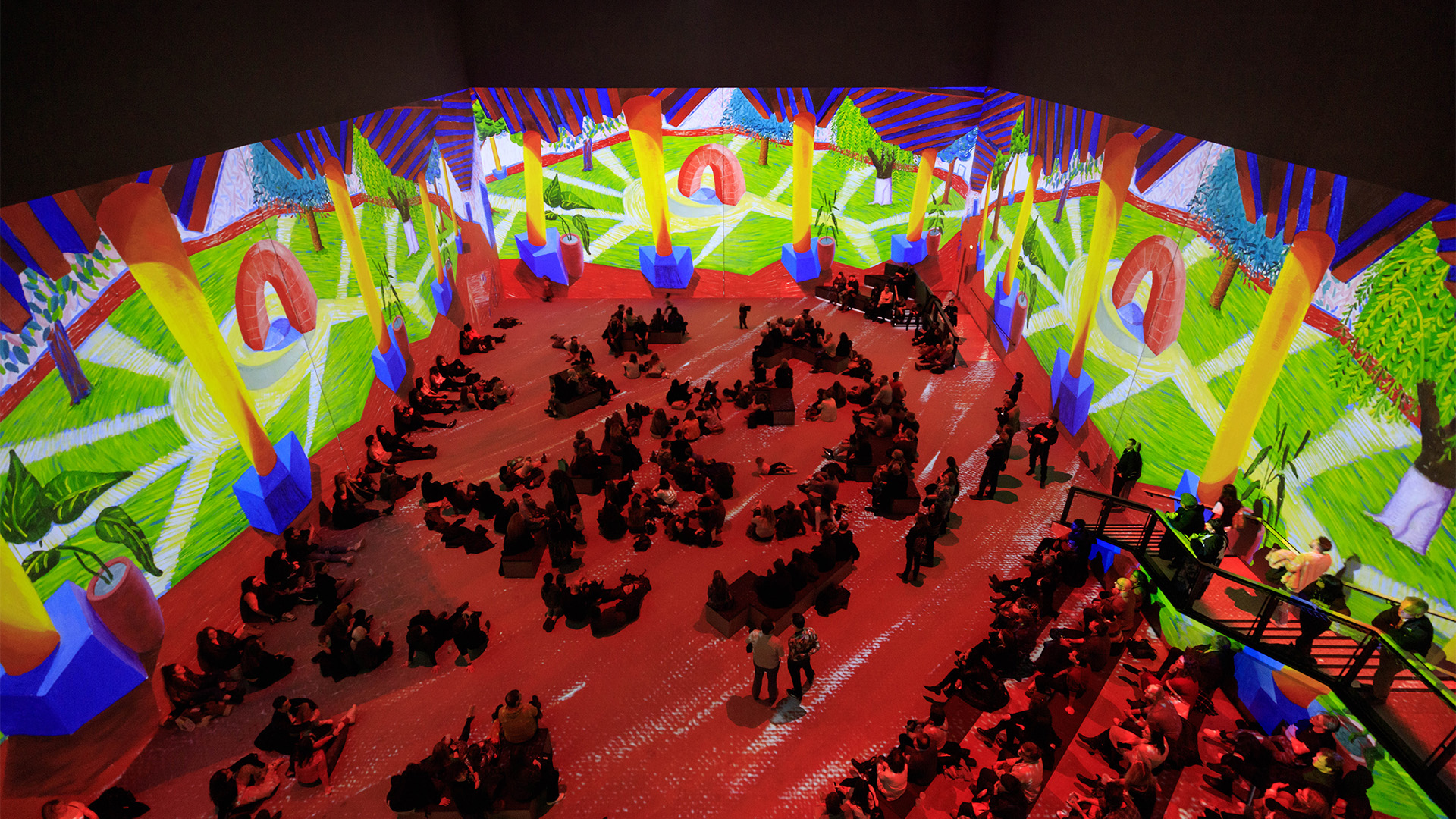 Wraparound screens project a bright, bold landscape painting by David Hockney at Lightroom.
