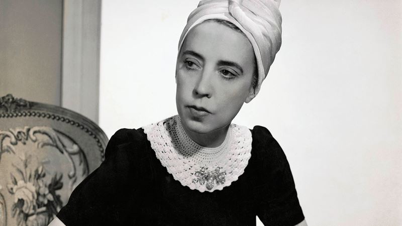 Vogue 1940 showing Elsa Schiaparelli wearing a black silk dress with crocheted collar of her own design and a turban.