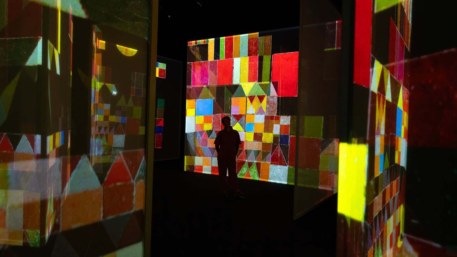 Explore the Art of Abstraction gallery at FRAMELESS. Image courtesy of FRAMELESS. The Art of Abstraction gallery at FRAMELESS with squares of colours reflecting on several walls.