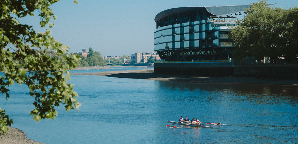 Rowers sail past Fulham Pier on a sunny day