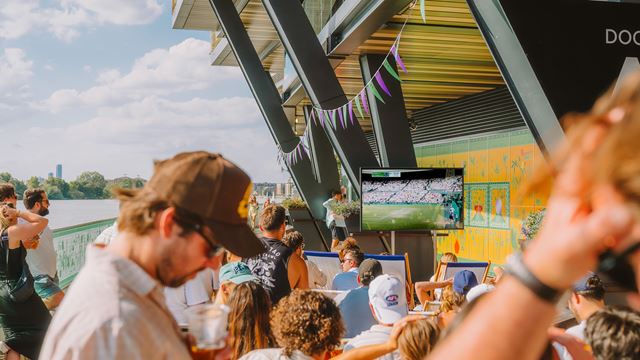 People watch Wimbledon on a TV screen at Fulham Pier