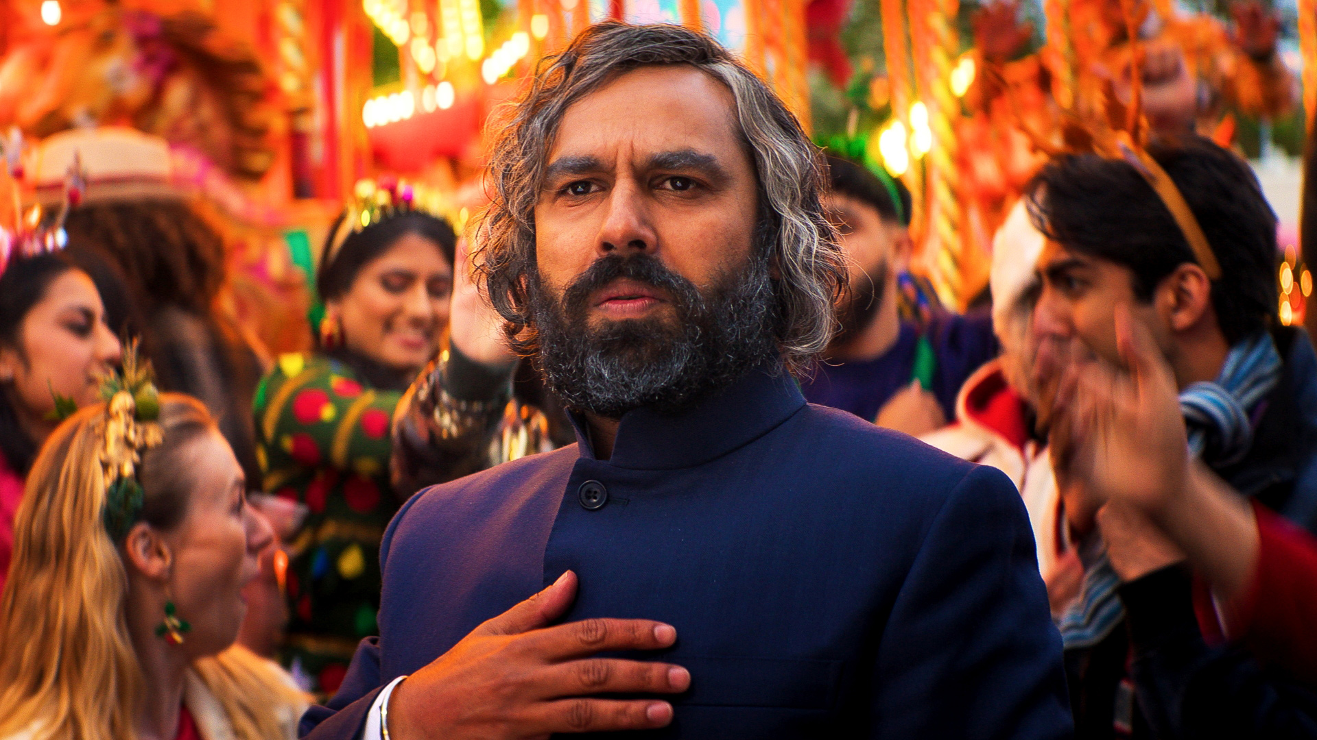 A still of Kunal Nayyar in Christmas Karma with a festive London market in the background