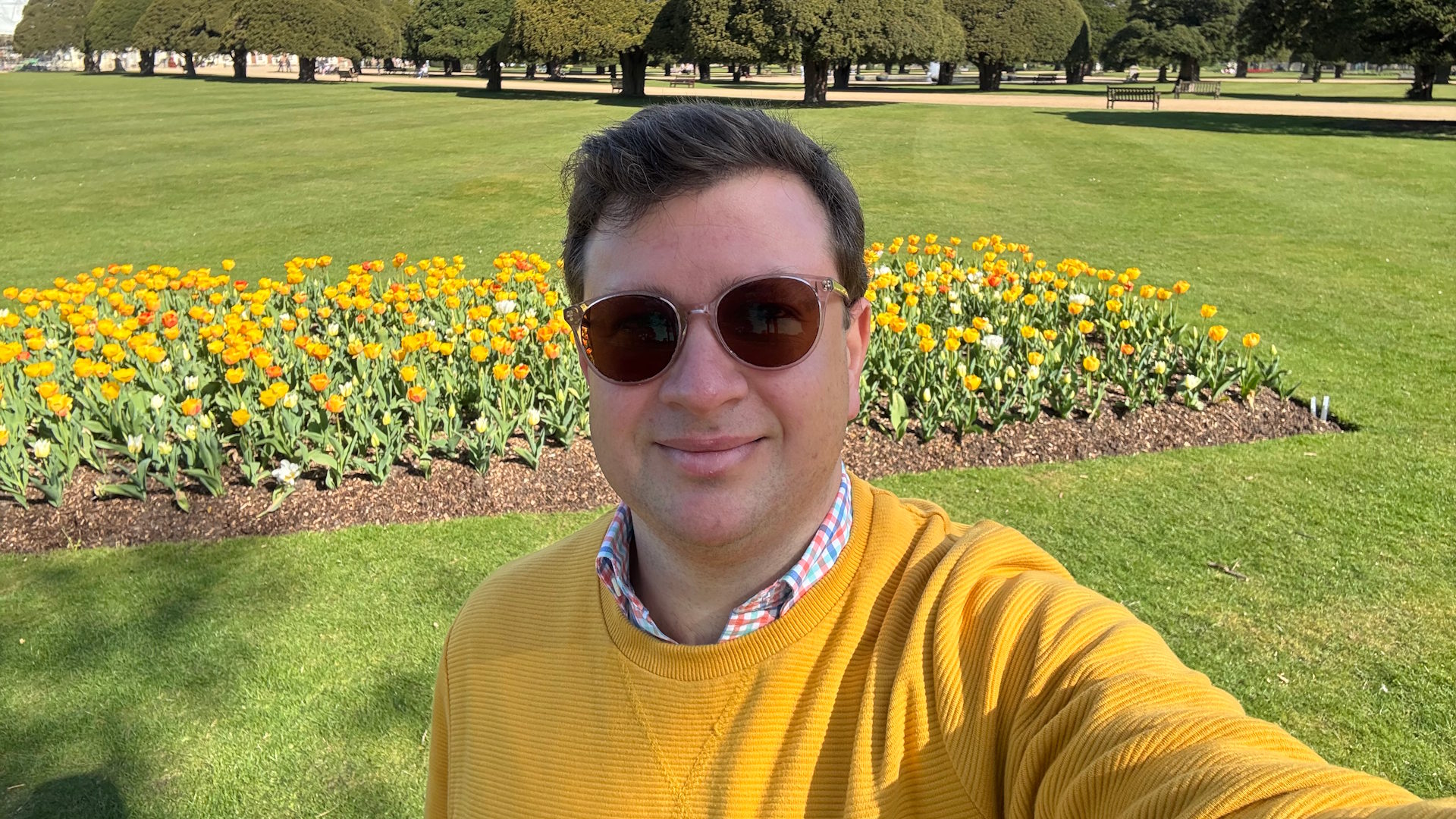 Our author Jonny Payne, taking a selfie in front of a bed of yellow tulips in the Great Fountain Garden at Hampton Court Palace.