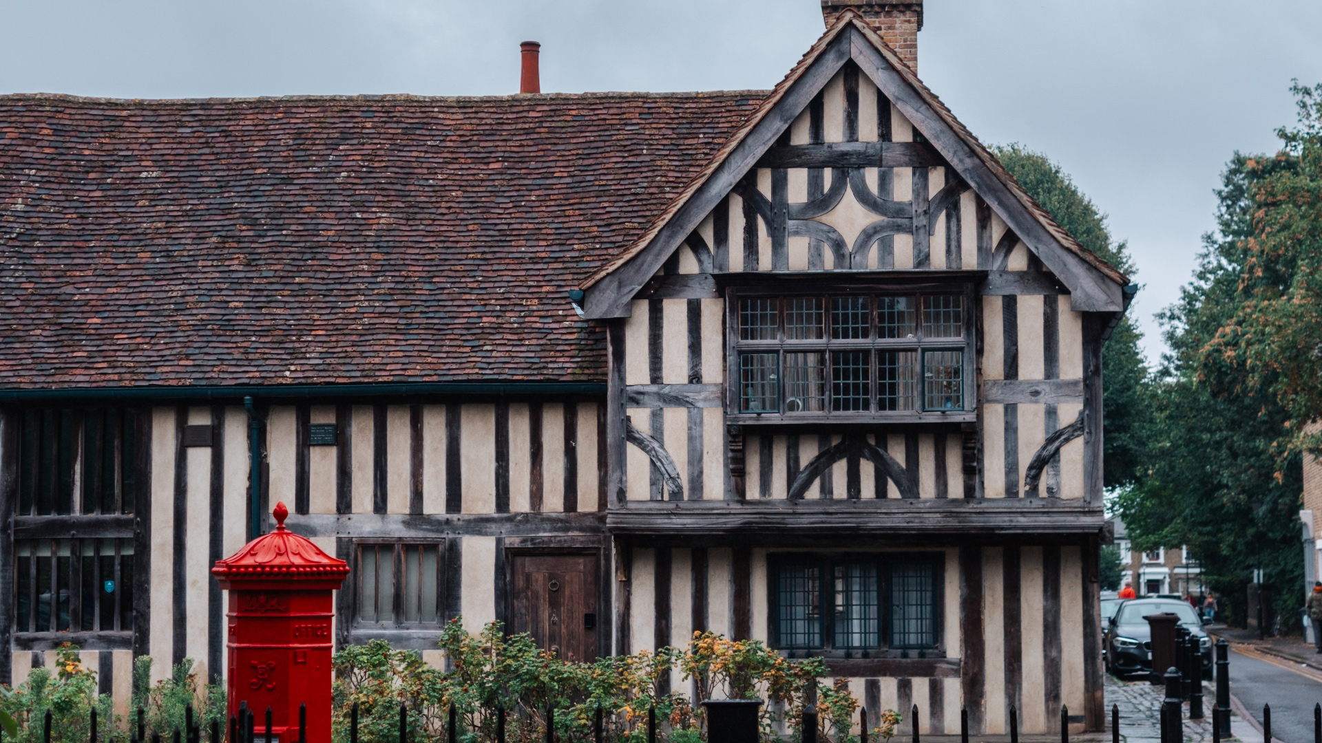 A photo of an old building in Walthamstow with wood panelled exterior and an old-fashioned red letterbox outside the front