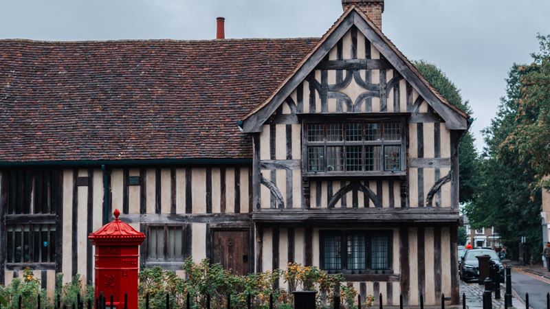 Walthamstow. Credit: Jou Jou Travels. Image courtesy of Jou Jou Travels. A photo of an old building in Walthamstow with wood panelled exterior and an old-fashioned red letterbox outside the front