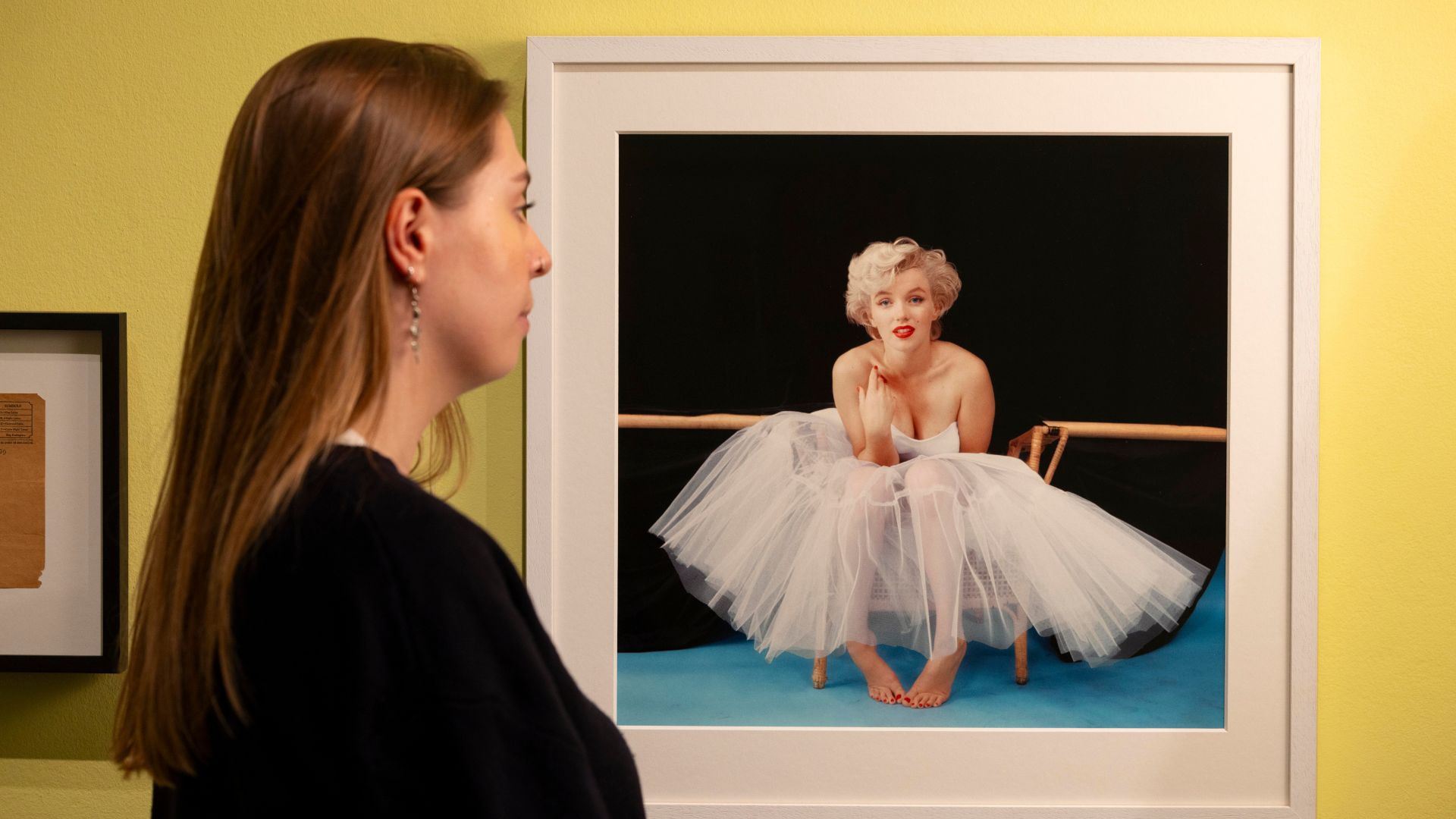 A visitor looks at a framed portrait photograph of Marilyn Monroe on display at the National Portrait Gallery.