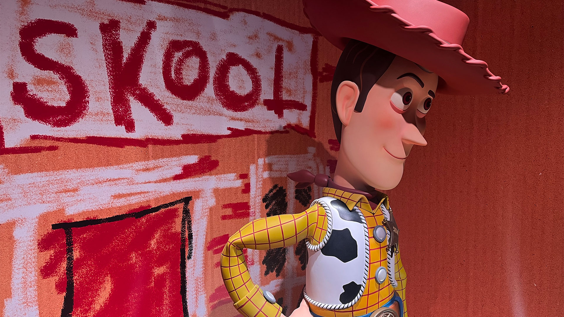 Come face-to-face with Andy's favourite toys when you visit the Toy Story rooms at Mundo Pixar! Photo credit: Carole Rocton. Woody, the cowboy toy, stands in one of the rooms at Mundo Pixar, wearing his traditional costume: a yellow shirt, a gilet with a cow pattern, and a brown leather hat.