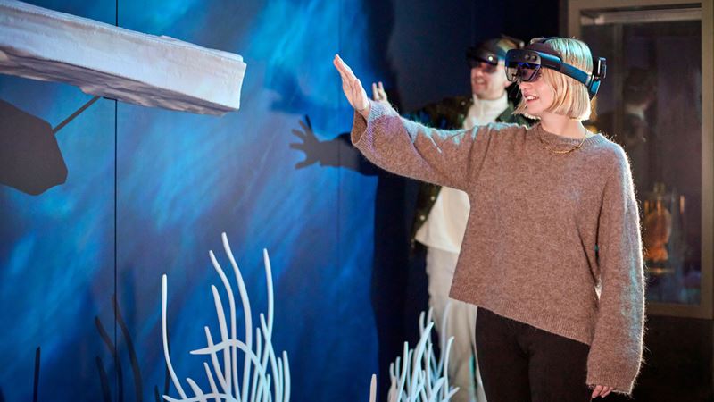 A man and a woman with mixed-reality headsets at the Visions of Nature, a mixed reality experience, in NHM's Darwin Centre 1.