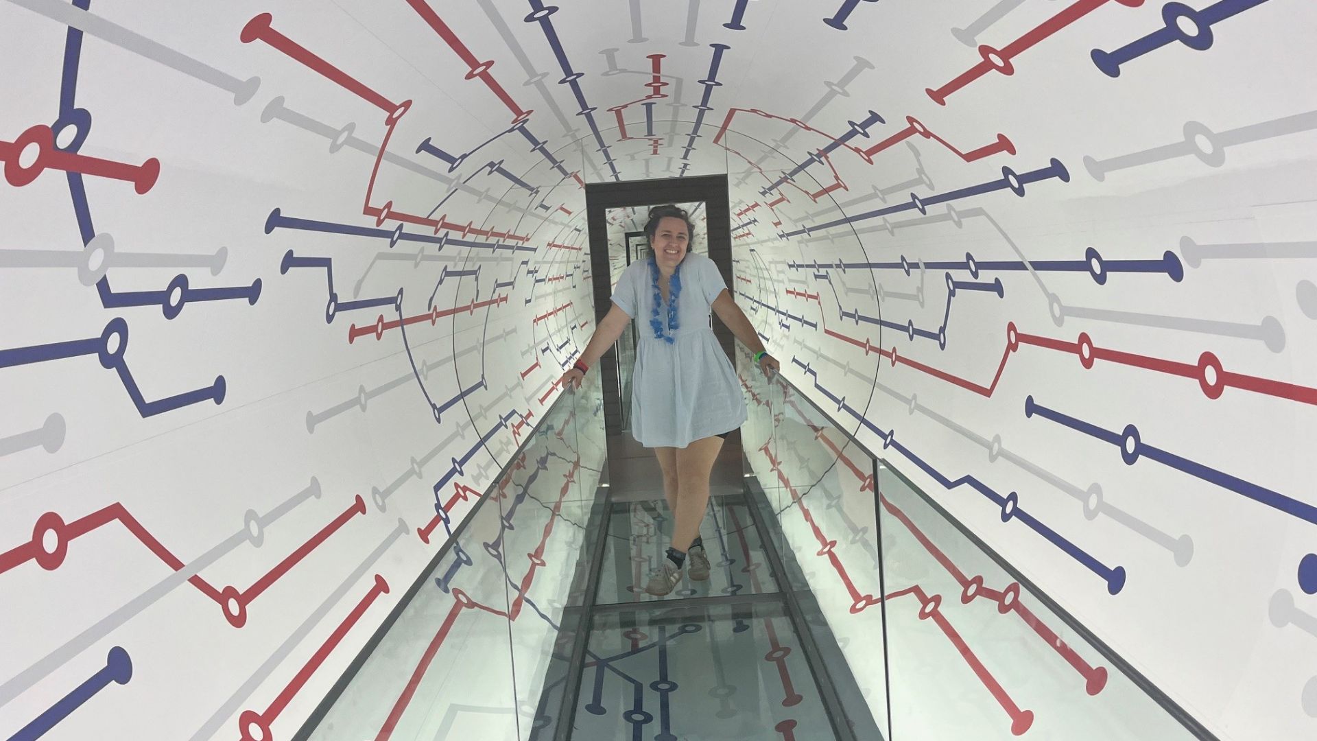 Person walking on walkway through a tunnel made to look like the London Underground Tube network.