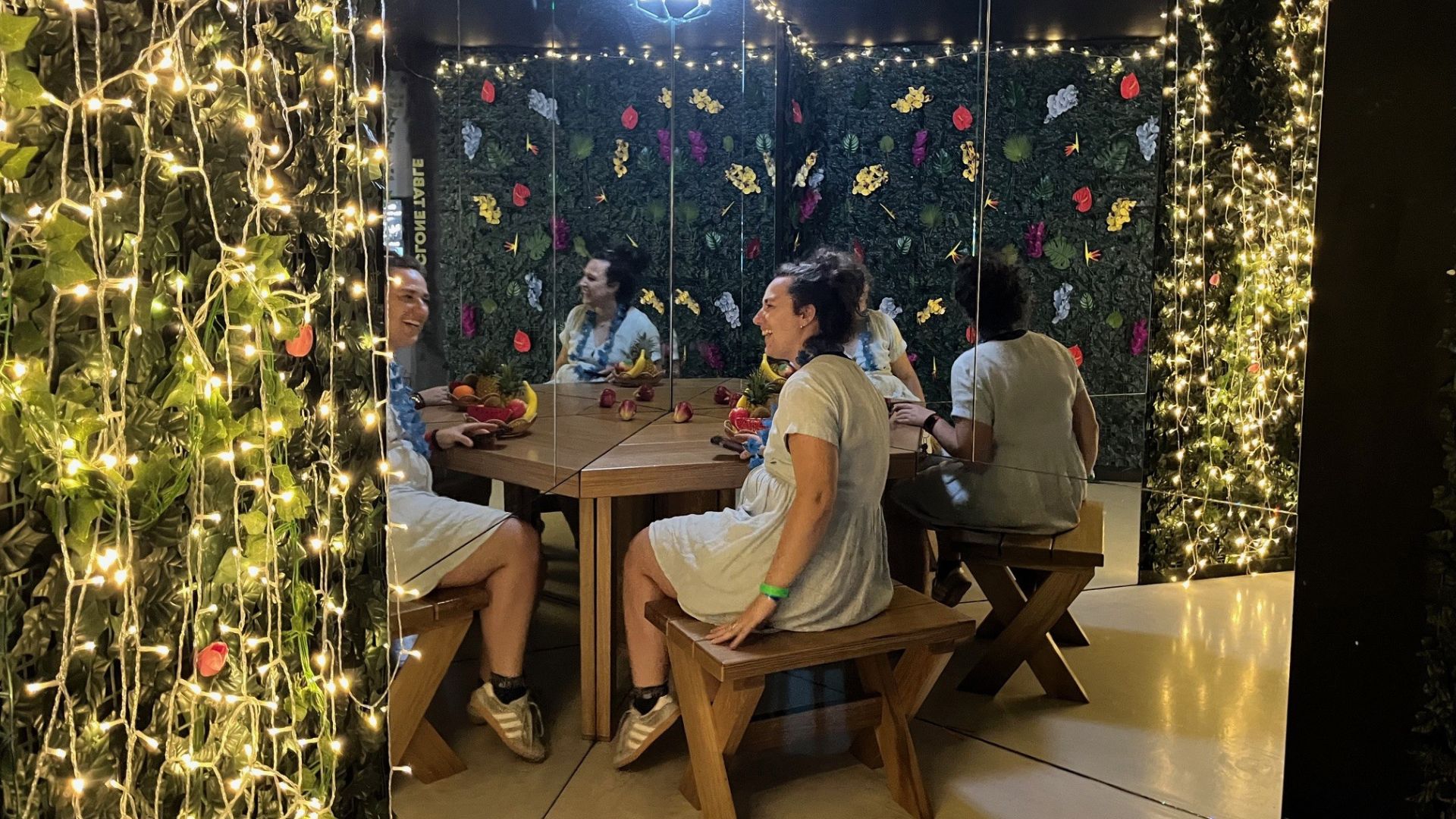Explore the interactive exhibits at Paradox Museum. © Visit London/Charlotte Pritchard. Person sitting at table in mirror room with a woodland theme.