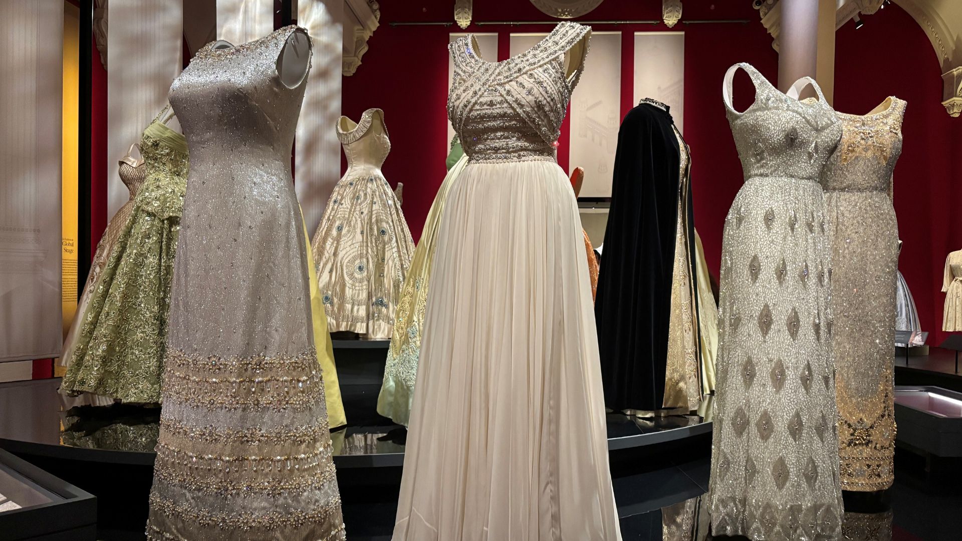 Admire dresses worn for landmark moments at Queen Elizabeth II: Her Life in Style. © Visit London/Charlotte Pritchard. Silver embellished dresses lined up at Queen Elizabeth II: Her Life in Style.