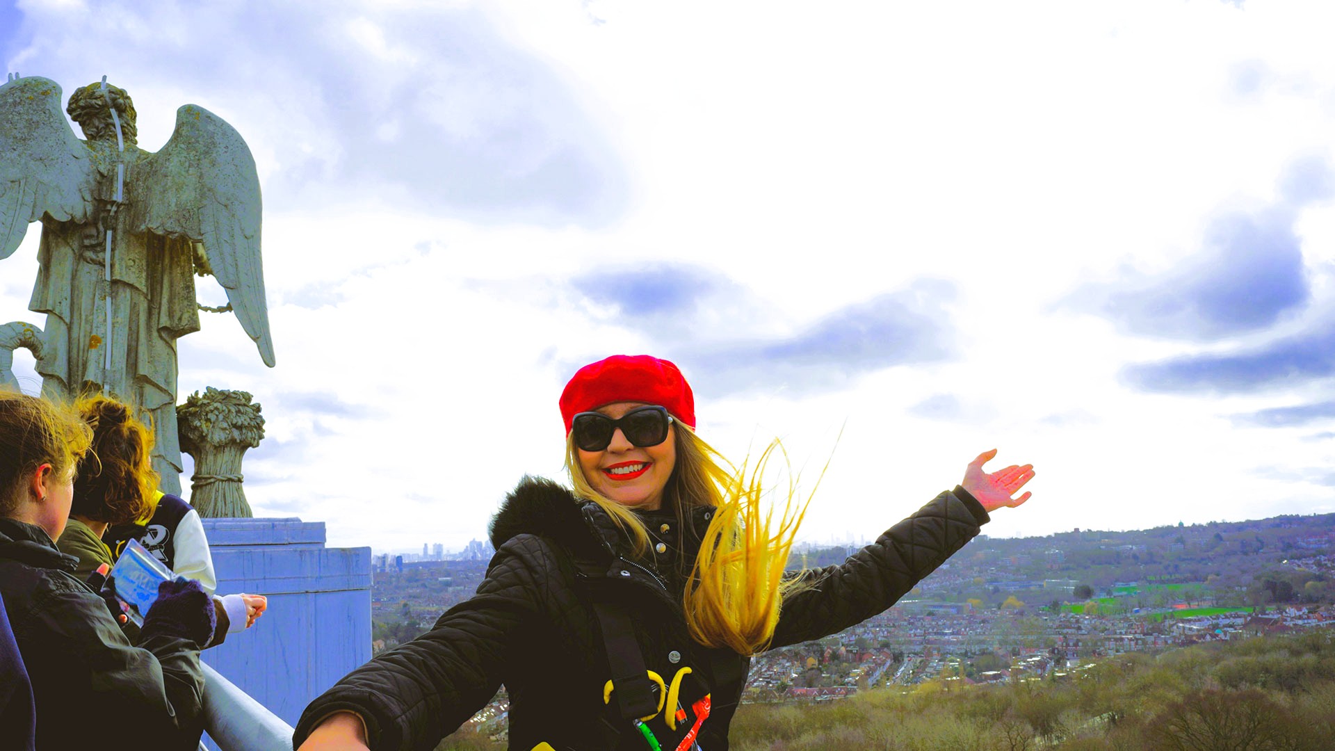 A blonde girl wearing a red beret showcasing the views of London from the Summit at Alexandra Palace