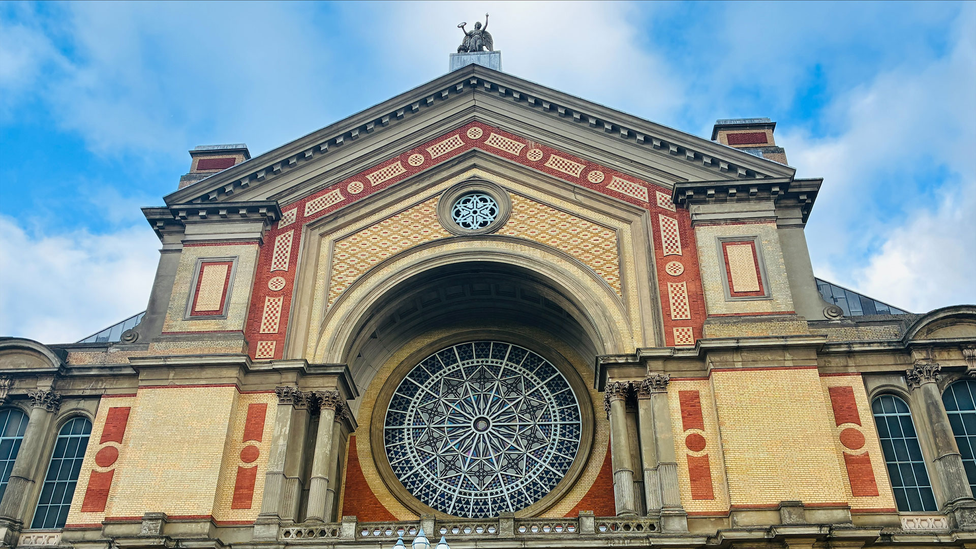 Are you ready to summit? Experience Ally Pally's Rooftop Adventure © Chantal Welch. Image courtesy of Chantal Welch. The exterior of Alexandra Palace with the large Victorian rose window and Angel of Plenty statue in view.