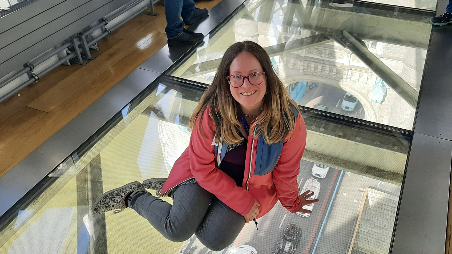 Visit Tower Bridge on a sunny day. Image courtesy of Visit London/Sigrun Tomicki A picture of a woman sitting on the glass floor inside Tower Bridge.