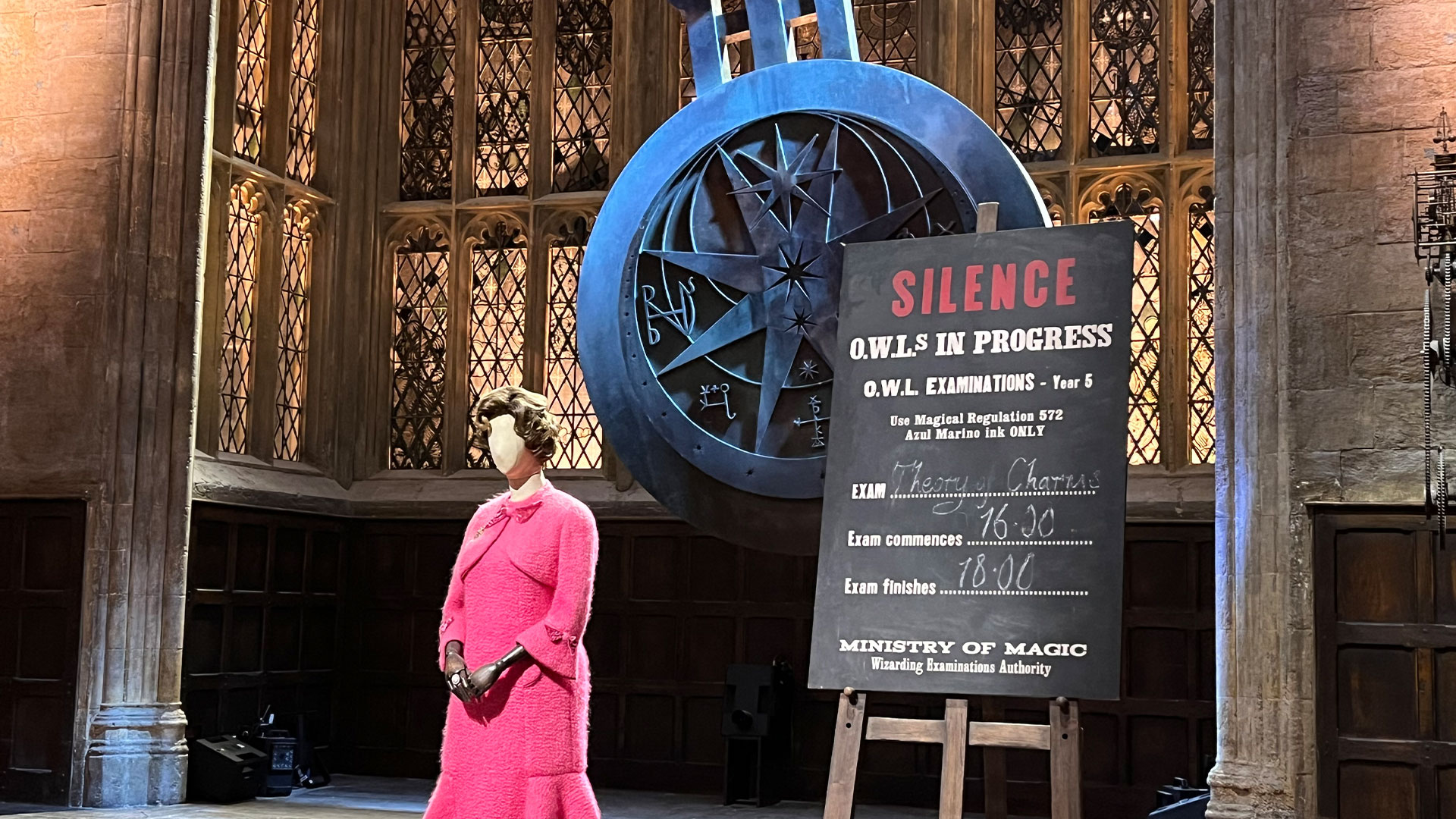Explore the new Magical Maschief theme at the Warner Bros. Studio Tour and discover the behind-the-scenes tricks that bring the magic to life. Photo credit: Carole Rocton A statue of Professor Umbridge, complete with her iconic pink skirt and jacket, stands in Hogwarts' Great Hall, with a swinging pendulum behind her.