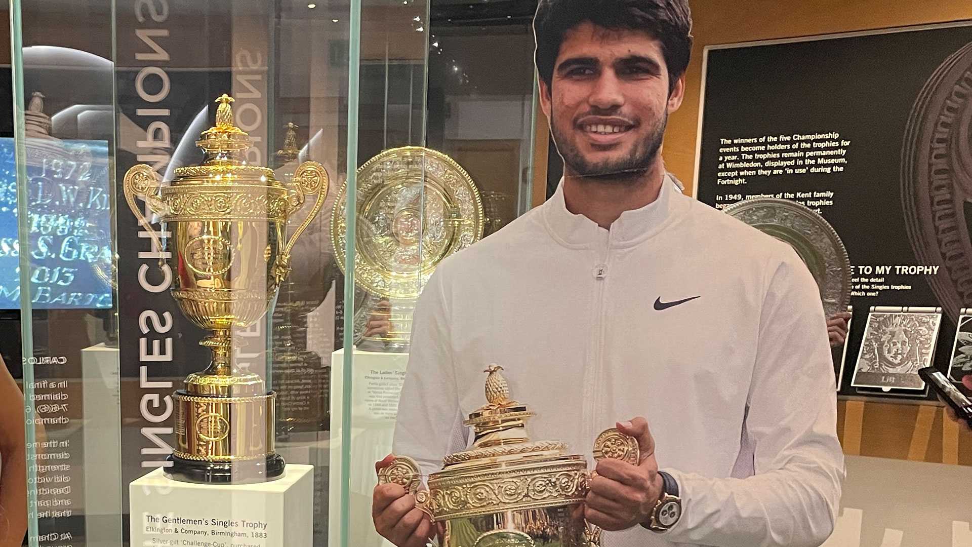 Step into tennis history at the Wimbledon Lawn Tennis Museum, where iconic moments and immersive exhibits celebrate The Championships. Image courtesy of Chantal Welch. A cardboard cut out of tennis player Carlos Alcaraz by the tennis trophies at the Wimbledon Museum