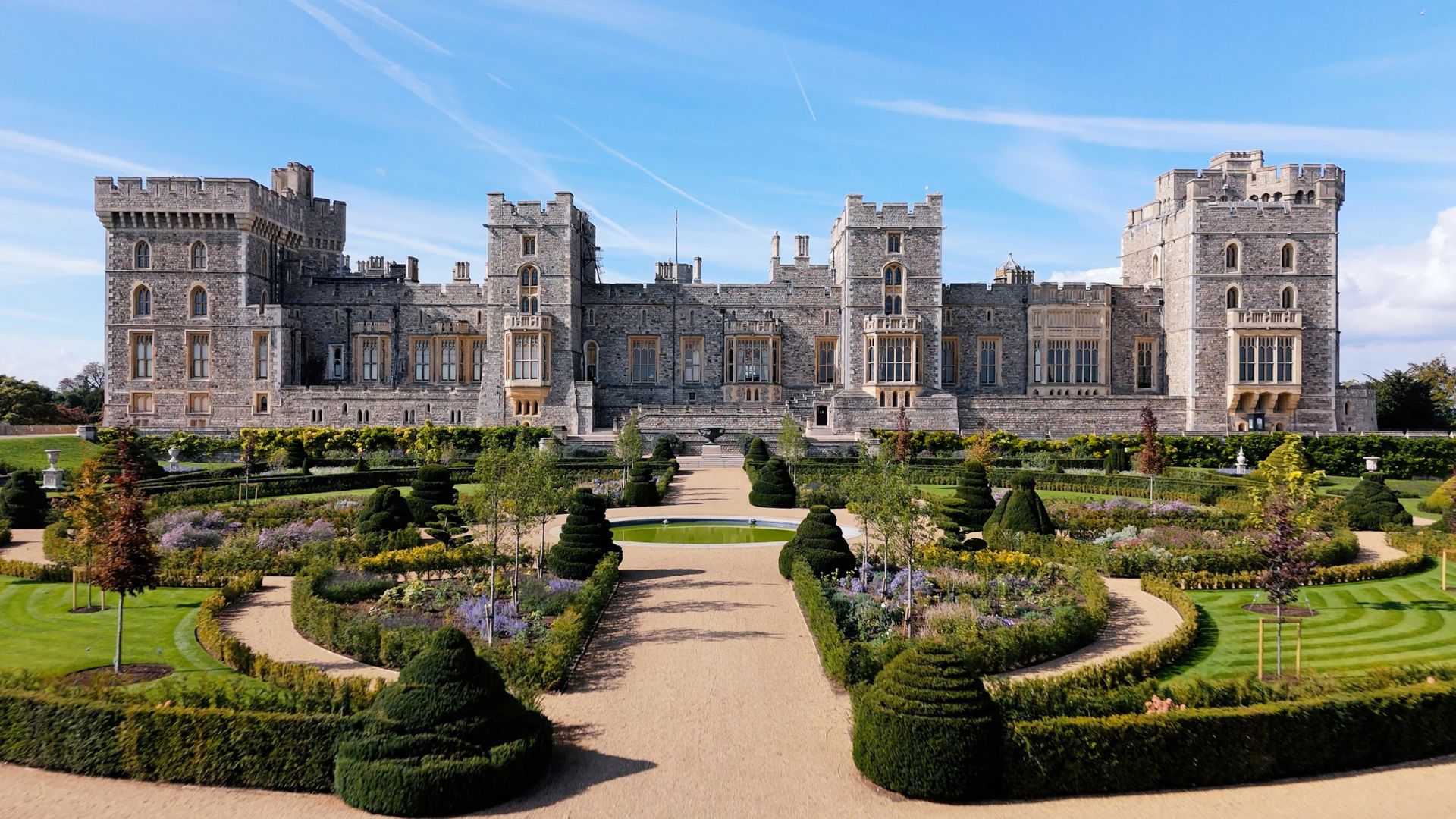 The landscaped Venus Garden at Windsor Castle with curved hedges, flower beds and topiary set against the castle’s east façade.