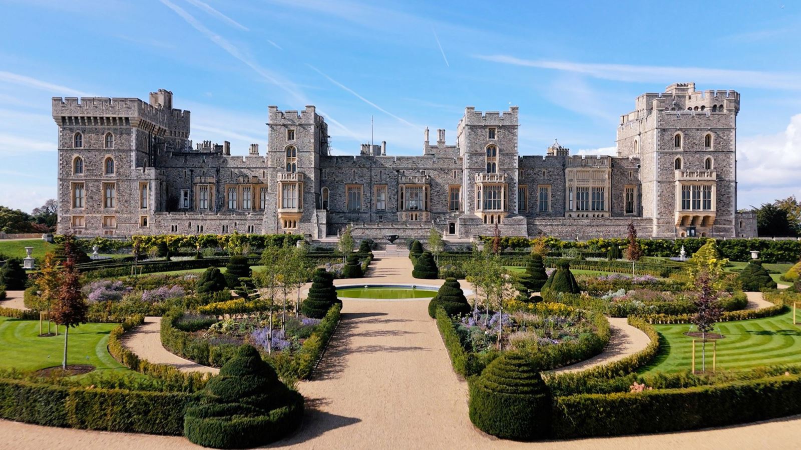 The landscaped Venus Garden at Windsor Castle with curved hedges, flower beds and topiary set against the castle’s east façade.