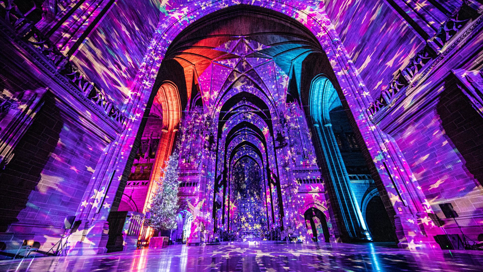 Liverpool Cathedral Christmas Luxmuralis 2022. Photo credit: Peter Walker. Image courtesy of Luxmuralis. Interior of Liverpool Cathedral featuring a light show with Christmas projections.