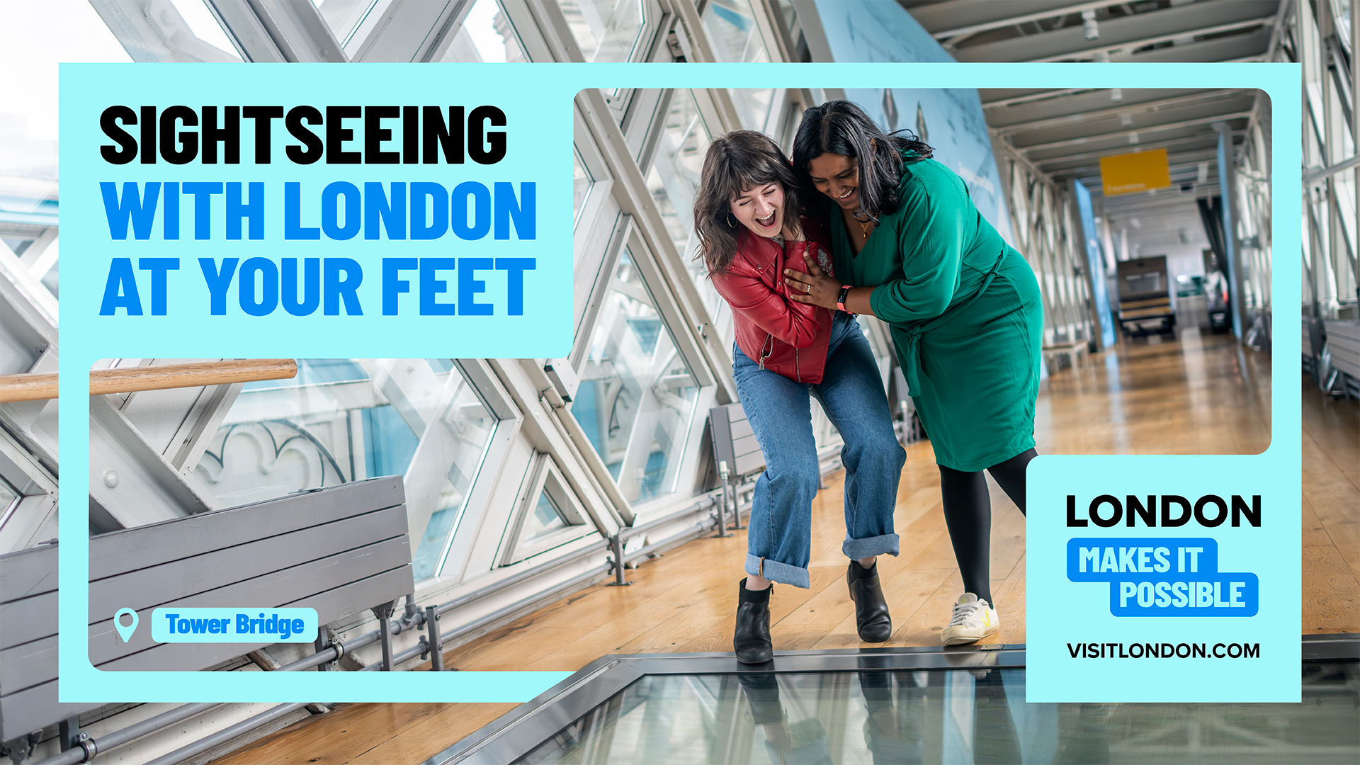 Two people cling to each other as they look down through the glass floor on one of Tower Bridge's walkways. Graphics on top show the wording 