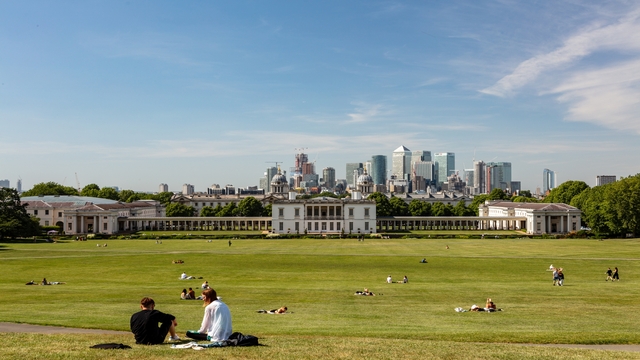A panoramic shot of the Naval Colleges in Greenwich Park, with the London skyline in the background.