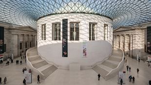 People walking through the Great Court at the British Museum in London on a sunny day
