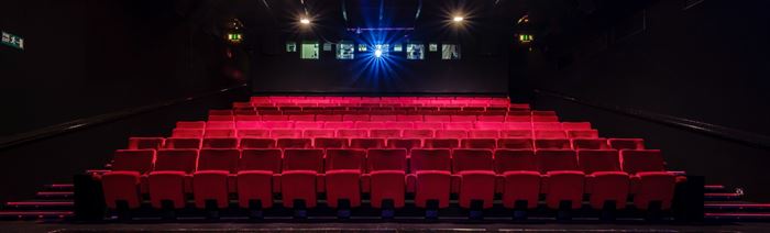 An empty screening room at BFI Southbank London with red seats and lights in the background.